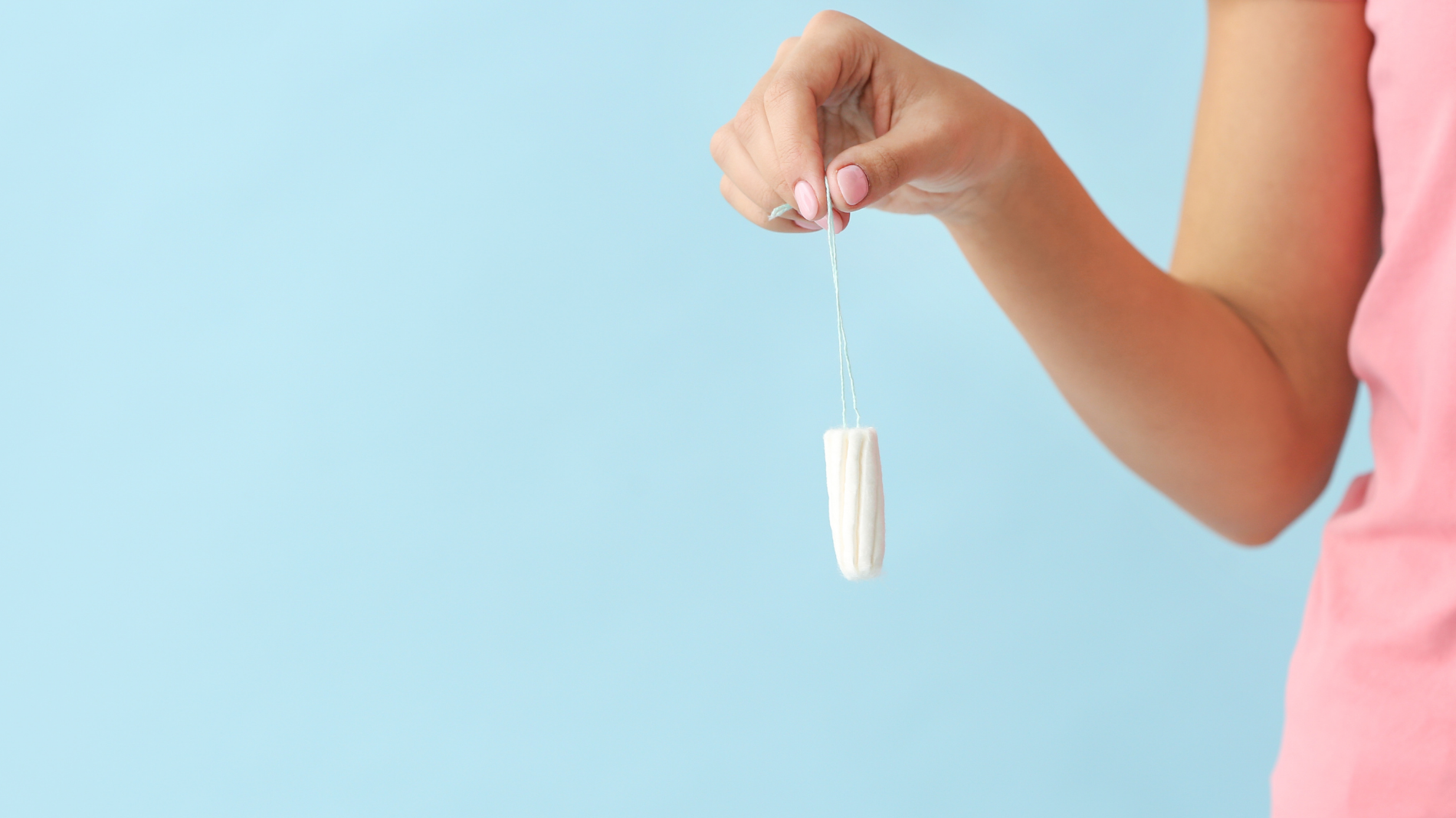 Hand holding a tampon to illustrate the importance of tampon veils — supporting blog about fibre loss, tampon safety, and reducing risk of infection or toxic shock syndrome.