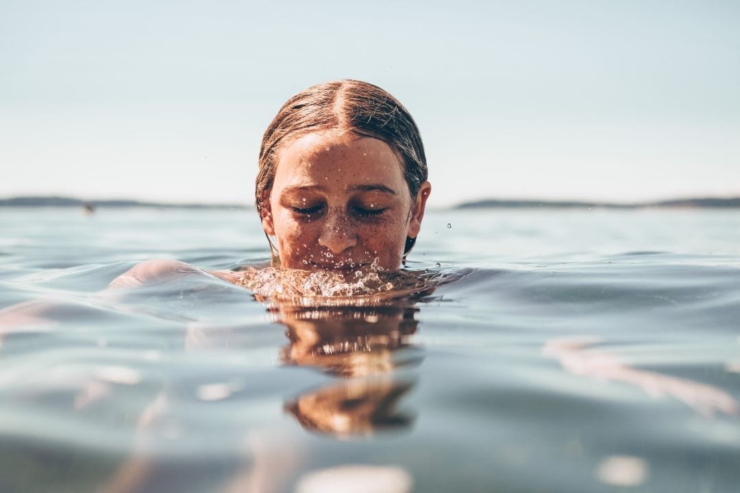 Girl swimming in the ocean.