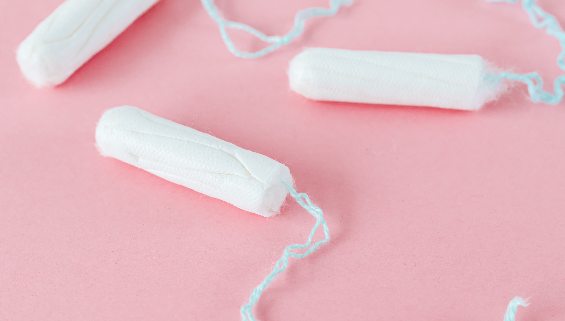Flat lay of white tampons on a pink background — addressing recent findings of trace metals in tampons and what they mean for menstrual health and safety.