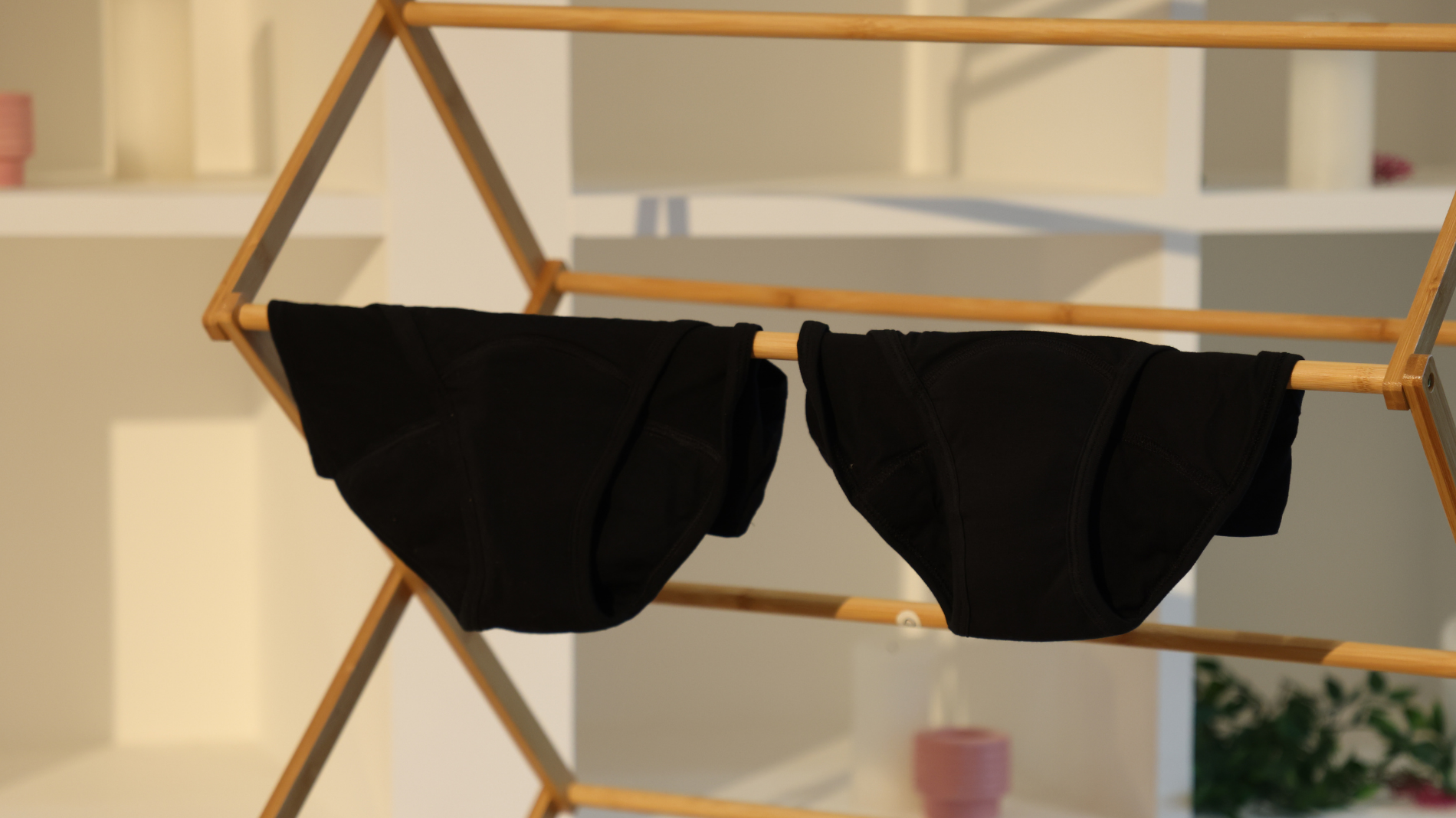 Clean period pants drying on a laundry rack — demonstrating proper care after washing and how to safely include reusable period underwear in your regular laundry routine.