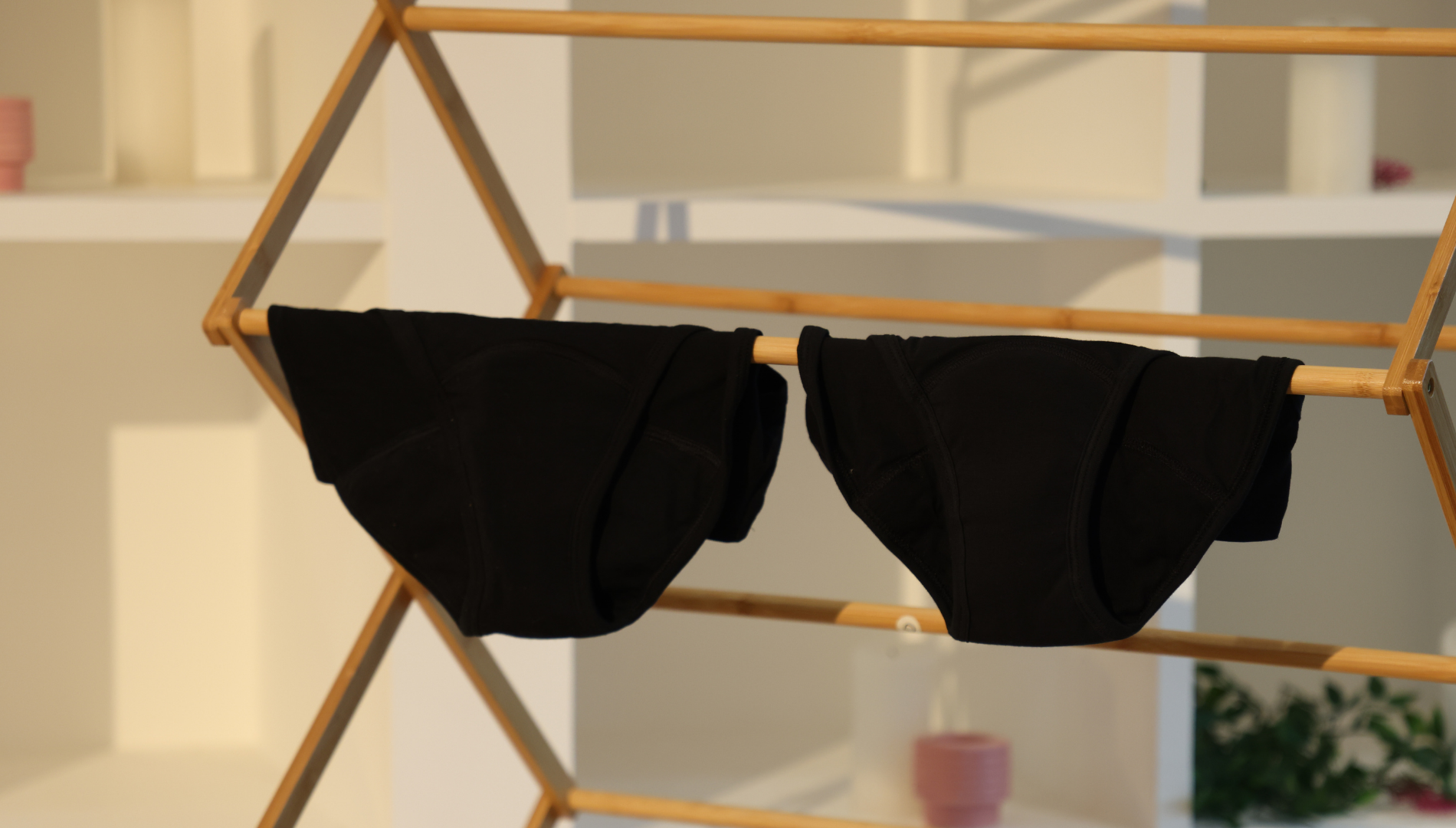 Clean period pants drying on a laundry rack — demonstrating proper care after washing and how to safely include reusable period underwear in your regular laundry routine.