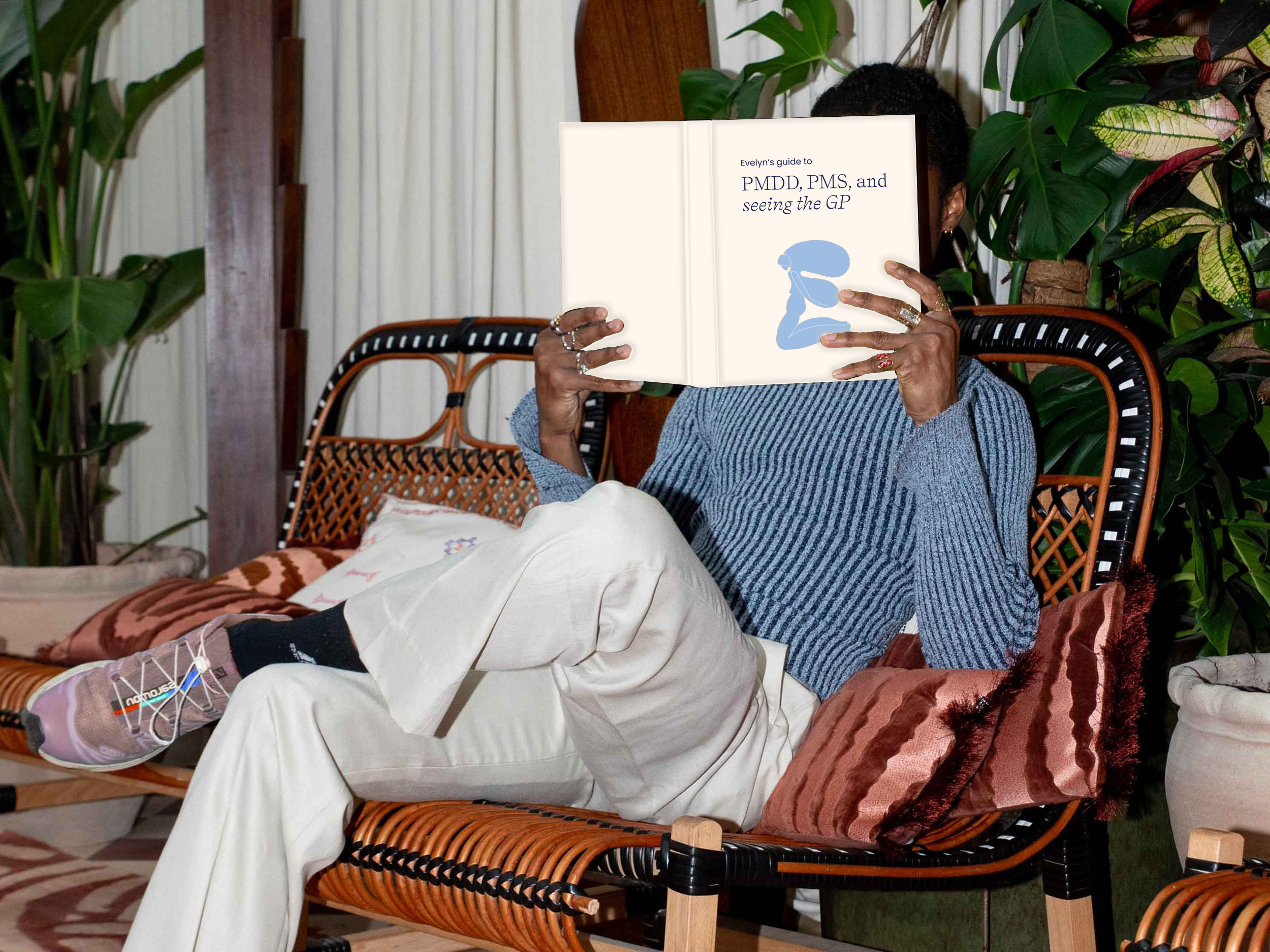 Person sat down reading Evelyn guide to PMDD, PMS and seeing the GP