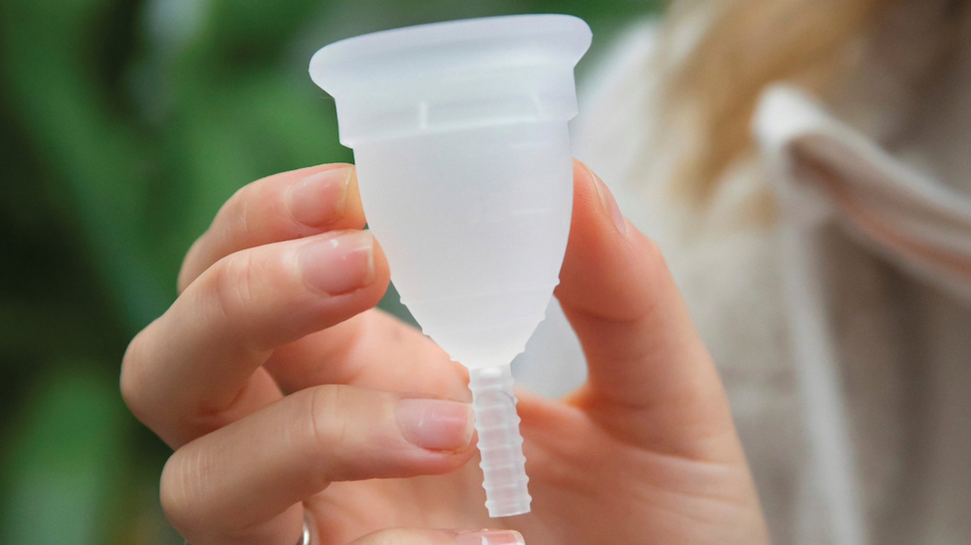Close-up of a Mooncup menstrual cup showing the flexible stem, designed for comfortable placement inside the vagina