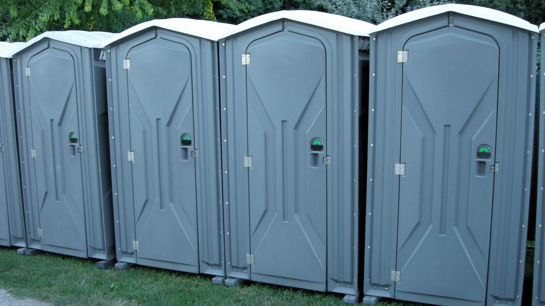 A row of festival porta loos – a familiar sight at outdoor events, highlighting the importance of period prep and hygiene when camping in the great outdoors
