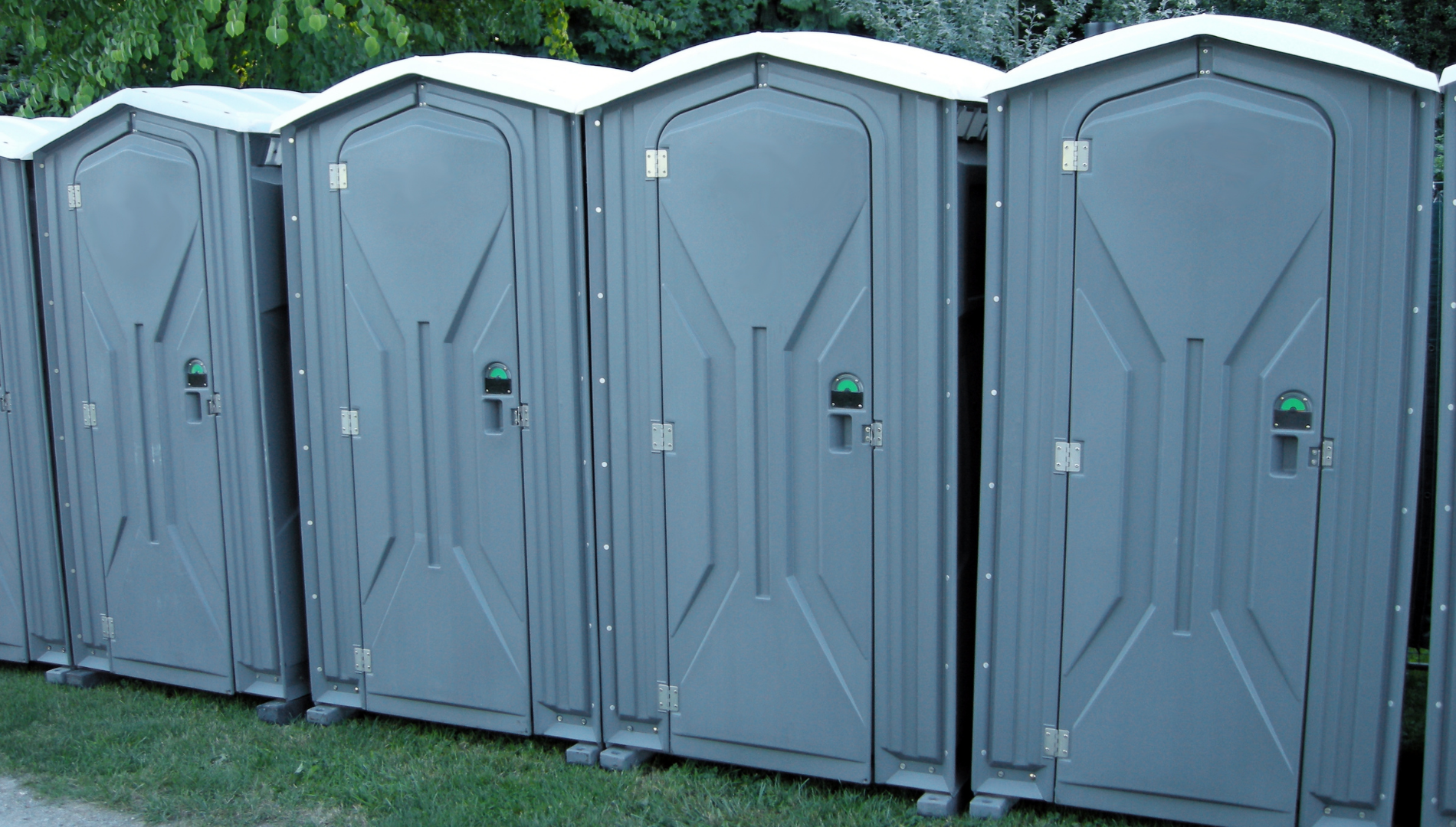 A row of festival porta loos – a familiar sight at outdoor events, highlighting the importance of period prep and hygiene when camping in the great outdoors
