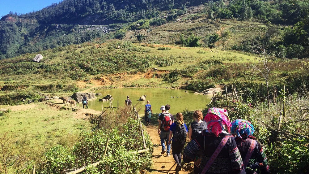 A group of backpackers walking down into a valley.