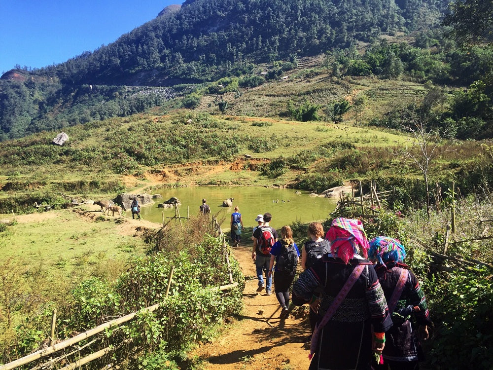 A group of backpackers walking down into a valley.