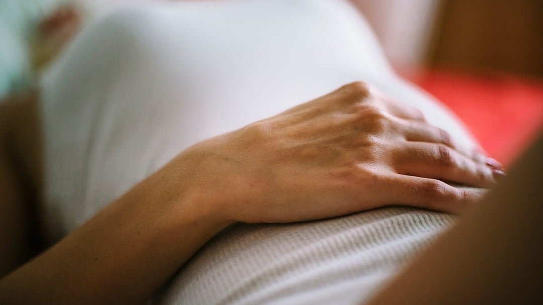Woman lying down with hand on tummy.